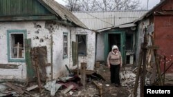 A woman walks out of her damaged house in the town of Debaltseve, northeast of Donetsk, on March 17.