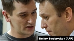 Russian opposition leader Aleksei Navalny (right) listens to his brother and co-defendant Oleg in a Moscow court in December 2014.