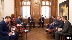 A handout photo made available by Syria's official Syrian Arab News Agency shows Syrian President Bashar al-Assad (center right) meeting with a joint delegation comprising members of parliament from the EU Parliament and the Russian upper house, the Federation Council, on December 29.