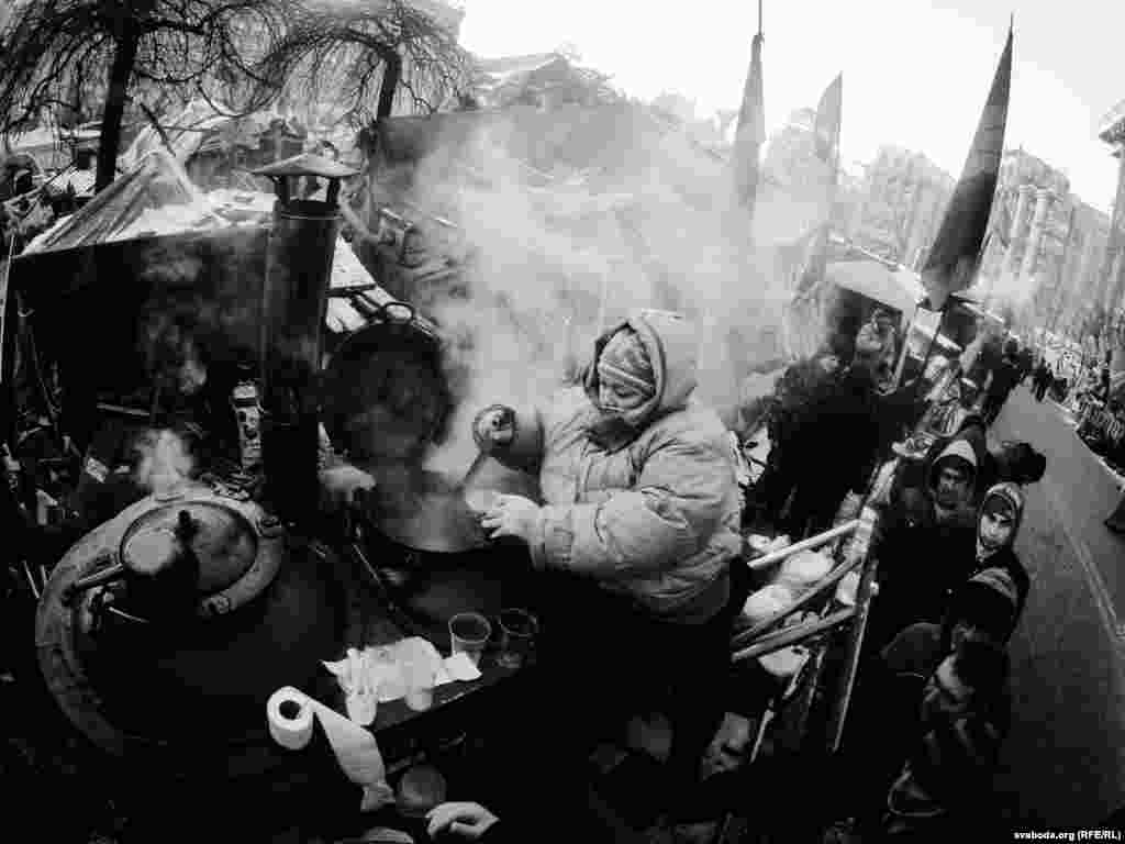 Protesters serve themselves hot drinks. Volunteers help prepare hot food and beverages, provided by donations.