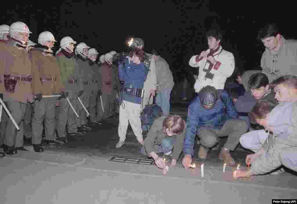 People light candles in front of a line of riot police who had stopped protesters from crossing a bridge on November 21.&nbsp;