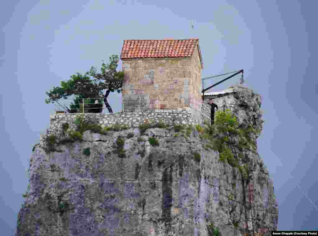 Maxime looks out from his favorite spot on the pillar. Troubled men come to stay and ask for guidance from Maxime and the young priests who live at the site. Maxime usually climbs down from the pillar once or twice a week for night prayers and to speak with the men.