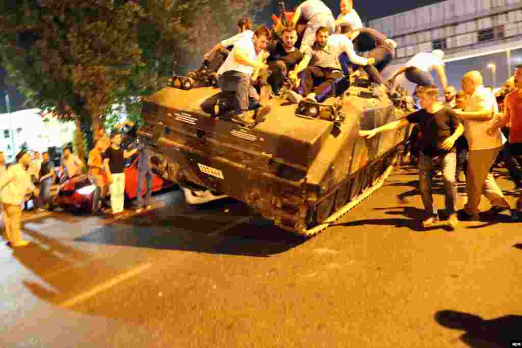 A tank, crowded with civilians, drives over two cars in Istanbul in the early hours of July 16.