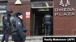 Полиция ходимлари Навальнийнинг Коррупцияга қарши кураш жамғармаси офиси олдида рейд ўтказиш учун йиғилмоқда. 2018 йил, 28 январда ўтказилган рейд олдидан олинган сурат.