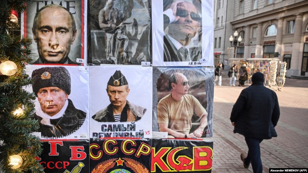 Мъж преминава покрай магазин за сувенири в Москва. На тениските е изобразен президентът Путин, гербът на СССР и надписът КГБ. 16 февруари 2022 г.