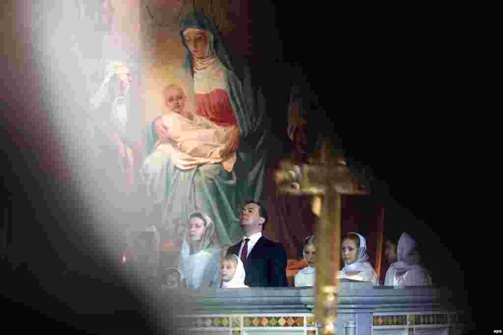 In Russia, Prime Minister Dmitry Medvedev and his wife, Svetlana Medvedeva, attend a Christmas service at Christ the Savior Cathedral in Moscow on January 7, 2014.