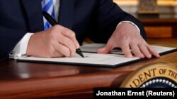 U.S. -- U.S. President Donald Trump signs a proclamation declaring his intention to withdraw from the JCPOA Iran nuclear agreement in the Diplomatic Room at the White House in Washington, U.S. May 8, 2018. 