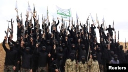 Syrian Islamist fighters hold up their weapons during a graduation ceremony at a camp in eastern al-Ghouta, near Damascus.