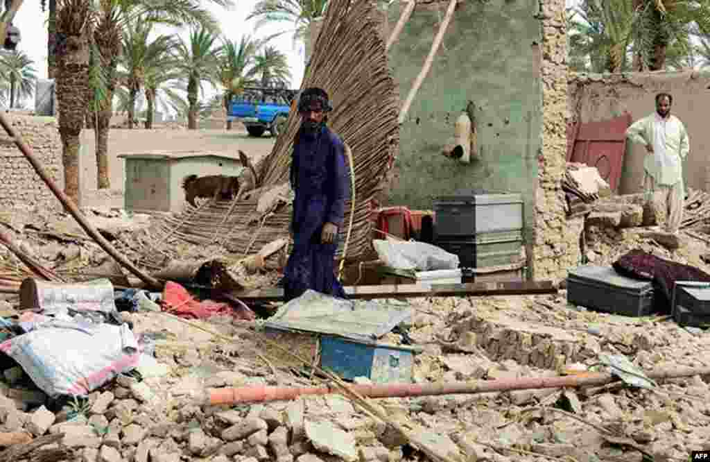 Residents look through the debris of a house, which collapsed after the earthquake hit the Awaran district in Balochistan Province.