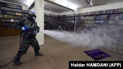 Әл-Наджаф қаласындағы діни кітапханада вирусқа қарсы дәрі шашып жүрген адам. Иран, 9 наурыз 2020 жыл.