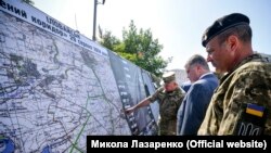 Президент України Петро Порошенко розглядає мапу із так званим «зеленим коридором» під Іловайськом 29 серпня 2014 року. Київ, 23 серпня 2018 року