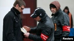 Članovi samoodbrane Krima proveravaju dokumenta ljudi na železničkoj stanici u Simferopolju
