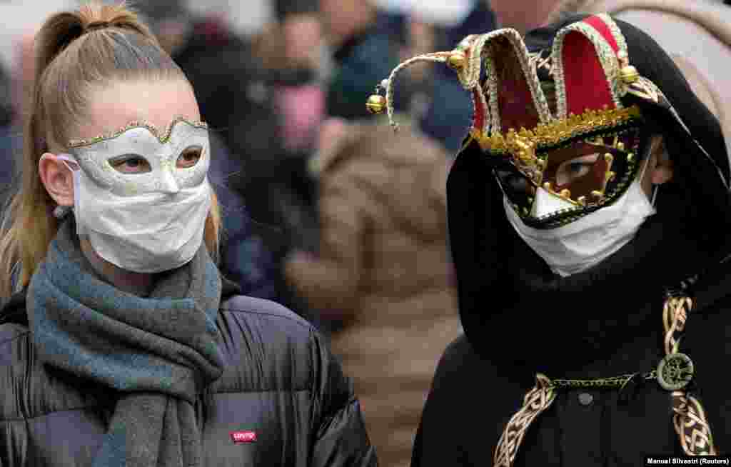 Туристы надевают карнавальные маски вместе с защитными