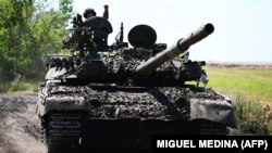 Ukrainian soldiers drive a T-72 tank on the front line in eastern Ukraine in July.