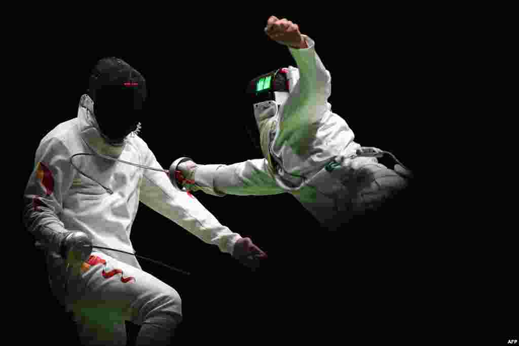 China's Jiao Yunlong (L) competes against Ukraine's Bogdan Nikishin during their men’s individual epee qualifying bout as part of the fencing competition.