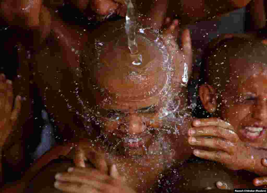 Young Hindu priests take a holy bath together as part of a ritual during the sacred thread festival at the Pashupatinath temple in Kathmandu, Nepal. Hindus take holy baths and change their sacred threads, also known as janai, for protection and purification during the festival. (Reuters/Navesh Chitrakar)