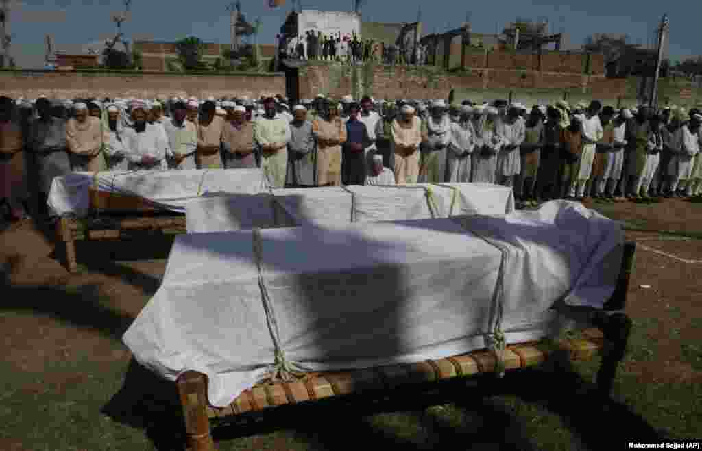 People offer funeral prayers for Pakistani villagers killed after the roof of their house caved in due to heavy rains, in Charsadda. (AP/Muhammad Sajjad)