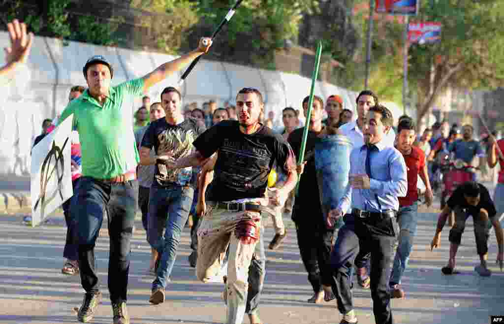 A supporter of deposed President Muhammad Morsi (center) is beaten by pro-government and army supporters during clashes that erupted on Tahrir Square and around the U.S. Embassy in Cairo on July 22. (AFP/Fayez Nureldine)