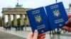 Українські закордонні паспорти на тлі Бранденбурзьких воріт у Німеччині