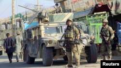 Afghan security forces keep watch in front of their armored vehicle in Kunduz city on October 4.