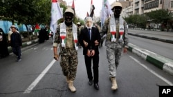 Iranian Basij paramilitary force members, dressed in the style of Palestinian and Lebanese militants, pretend to have detained Israeli Prime Minister Benjamin Netanyahu during a state-sponsored, pro-Palestinian rally after Friday Prayers in Tehran on October 13.