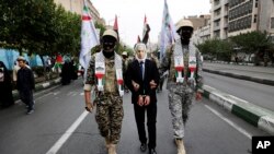 Anëtarët e forcave paraushtarake iraniane Basij, të veshur sikur militantë palestinezë dhe libanezë, improvizojnë arrestimin e kryeministrit izraelit Benjamin Netanyahu gjatë një tubimi pro-palestinez të sponsorizuar nga shteti, Teheran, 13 tetor 2023.