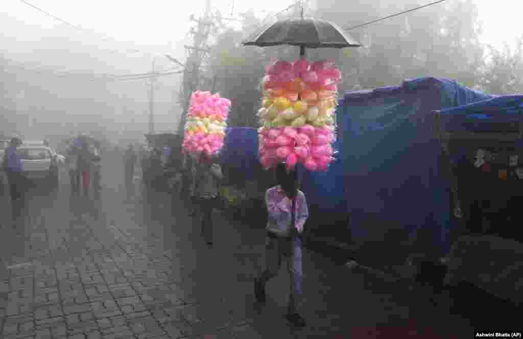 Traveling vendors sell cotton-candy on a foggy day in Dharmsala, India. (AP/Ashwini Bhatia)