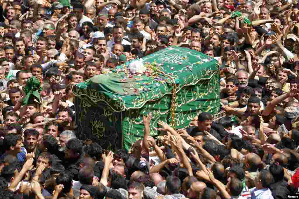 Shi&#39;ite pilgrims carry a mock coffin during a symbolic funeral marking the death anniversary of imam Musa al-Kadhim in Baghdad&#39;s Kadhimiyah District. (Reuters/Saad Shalash)