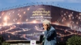 مردی در میدان ولی‌عصر تهران در حال عبور از کنار یک تابلوی تبلیغاتی جمهوری اسلامی علیه اسرائیل