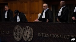 Presiding Judge Nawaf Salam (center) ask the parties to be seated before he starts reading the ruling of the International Court of Justice in The Hague on May 24.