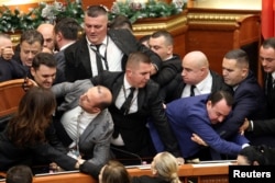 Deputetë të Partisë Demokratike, partisë më të madhe opozitare në Shqipëri, protestojnë brenda Kuvendit, në Tiranë, Shqipëri, 18 dhjetor 2025.