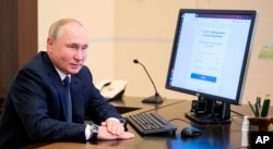 Президент России Владимир Путин наблюдает за дистанционным электронным голосованием во время парламентских выборов в РФ. Москва, Ново-Огарево, 17 сентября 2021 года