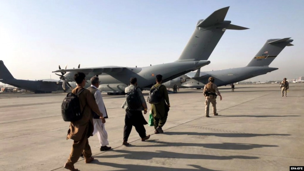People line up to board a military aircraft as they are evacuated from Kabul. (file photo)