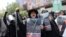 People attend an anti-Israeli protest in Tehran carrying portraits of generals and nuclear scientists killed in the Israeli strikes on Iran on June 13, 2025.