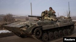 Ukrainian service members ride a BMP-1 infantry fighting vehicle near the frontline town of Bakhmut