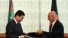 Afghan President Ashraf Ghani (R) exchanges documents with Turkmen President Gurbanguly Berdymukhamedov at the Presidential Palace in Kabul, in August.