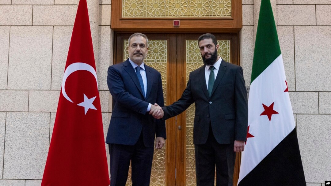 Türkiyə xarici işlər naziri Hakan Fidan Dəməşqdə Əhməd əl-Şaraa ilə əl sıxır.