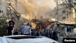 Urmările unu atac despre care presa iraniană a spus că a fost realizat de Israel asupra unei clădiri din apropierea ambasadei Iranului la Damasc.