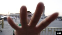 A plainclothes policemen tries to stop a journalist from taking photographs outside Tiananmen Square in Beijing.