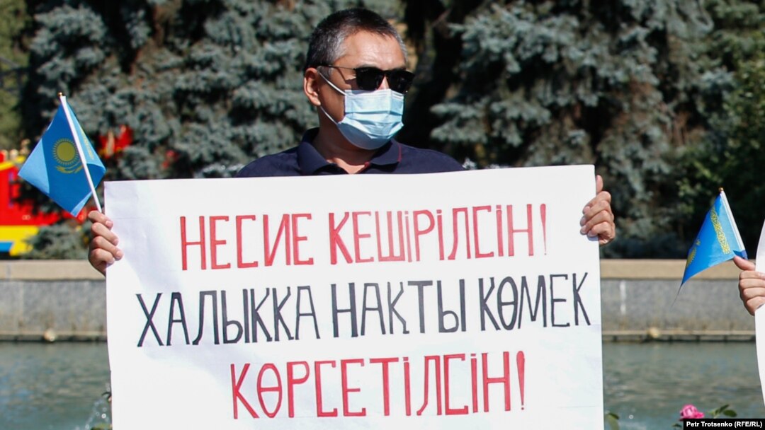 Билік келісім берген митингіде халыққа несие амнистиясын жариялау туралы талап жазылған плакат ұстап тұрған адам. Алматы, 13 қыркүйек 2020 жыл.