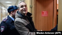 Dennis Christensen is escorted into a courtroom to hear his verdict in the town of Oryol on February 6.