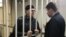 Oyub Titiyev (left) in the defendant's cage in a Chechen court on March 11