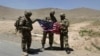 NATO soldiers stand with a U.S. flag after a security handover ceremony at a military academy outside Kabul in June.