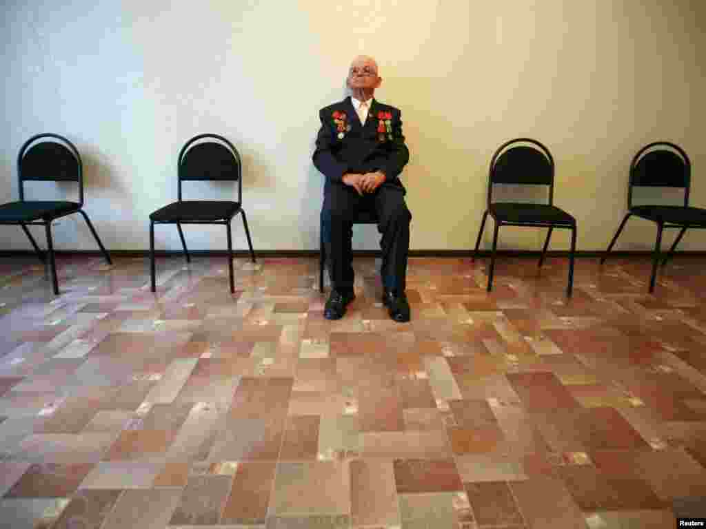 World War II veteran Alexei Vasilenko, 87, waits for the start of a ceremony in Stavropol on the eve of the 65th anniversary of the Allies' victory over Nazi Germany. Photo by Eduard Korniyenko for Reuters