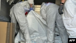 Red Cross representatives check body bags containing the remains of servicemen during an exchange of bodies at an undisclosed location in the Sumy region in August.