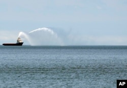 A ship sprays its water canons outside the port in Baku.