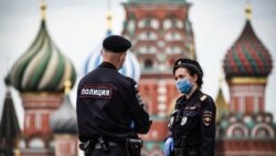 Сотрудники российской полиции в масках у здания Кремля.