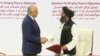 U.S. envoy Zalmay Khalilzad (left) and Mullah Abdul Ghani Baradar, the Taliban's top political leader, shake hands after signing a peace agreement in Doha on February 29.