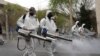 Firefighters wear protective face masks, amid fear of coronavirus disease, as they disinfect the streets, ahead of the Iranian New Year Nowruz, in Tehran, March 18, 2020