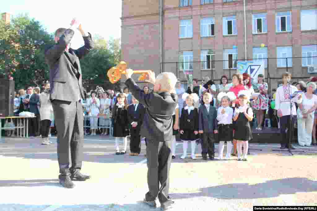 Одинадцятикласник передає першокласнику Роману Морозу ключ знань у Черкаській Спеціалізованій школі №17 